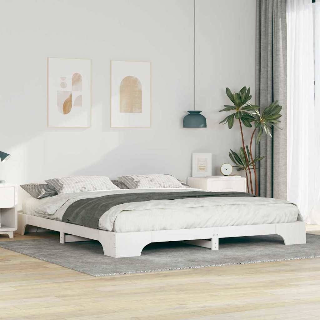 Schlafzimmer mit einem minimalistischen weißen Bett, zwei Wandkunstwerken, einer kleinen Pflanze und einer blauen Pendelleuchte vor Fenstern mit Vorhängen.