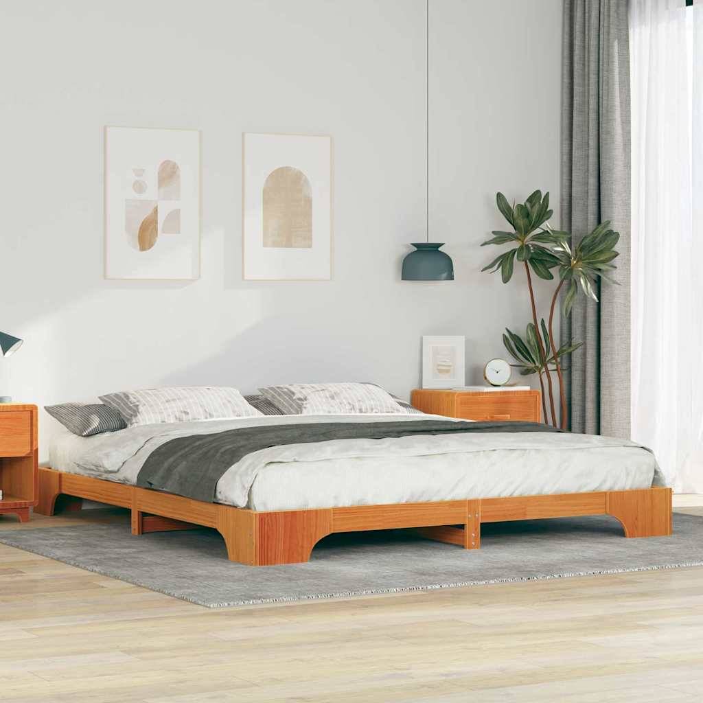 Ein minimalistisches Schlafzimmer mit einem Holzbett, grauen Bettwäsche, einer Pflanze, zwei abstrakten Wanddrucken und einem kleinen Nachttisch mit einer Lampe.
