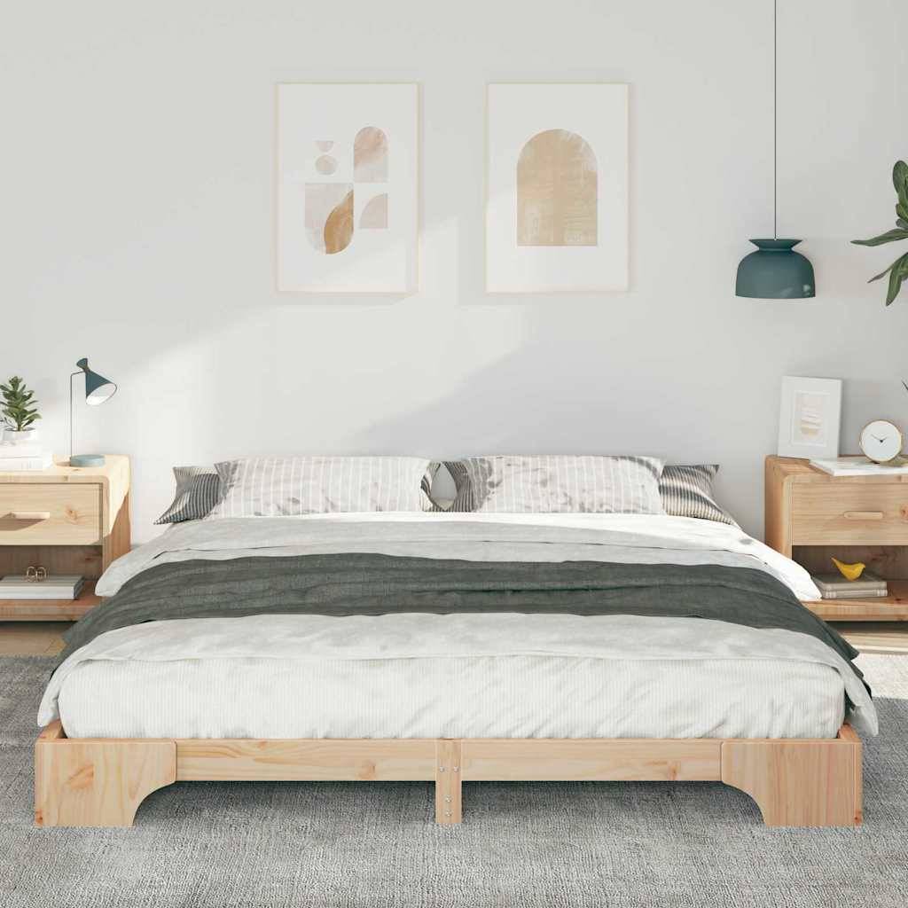 Ein ordentlich gemachtes Bett mit einem Holzrahmen, flankiert von zwei passenden Nachttischen mit Lampen. Schlichte Kunstwerke und eine petrolgrüne Pendelleuchte schmücken die Wand.