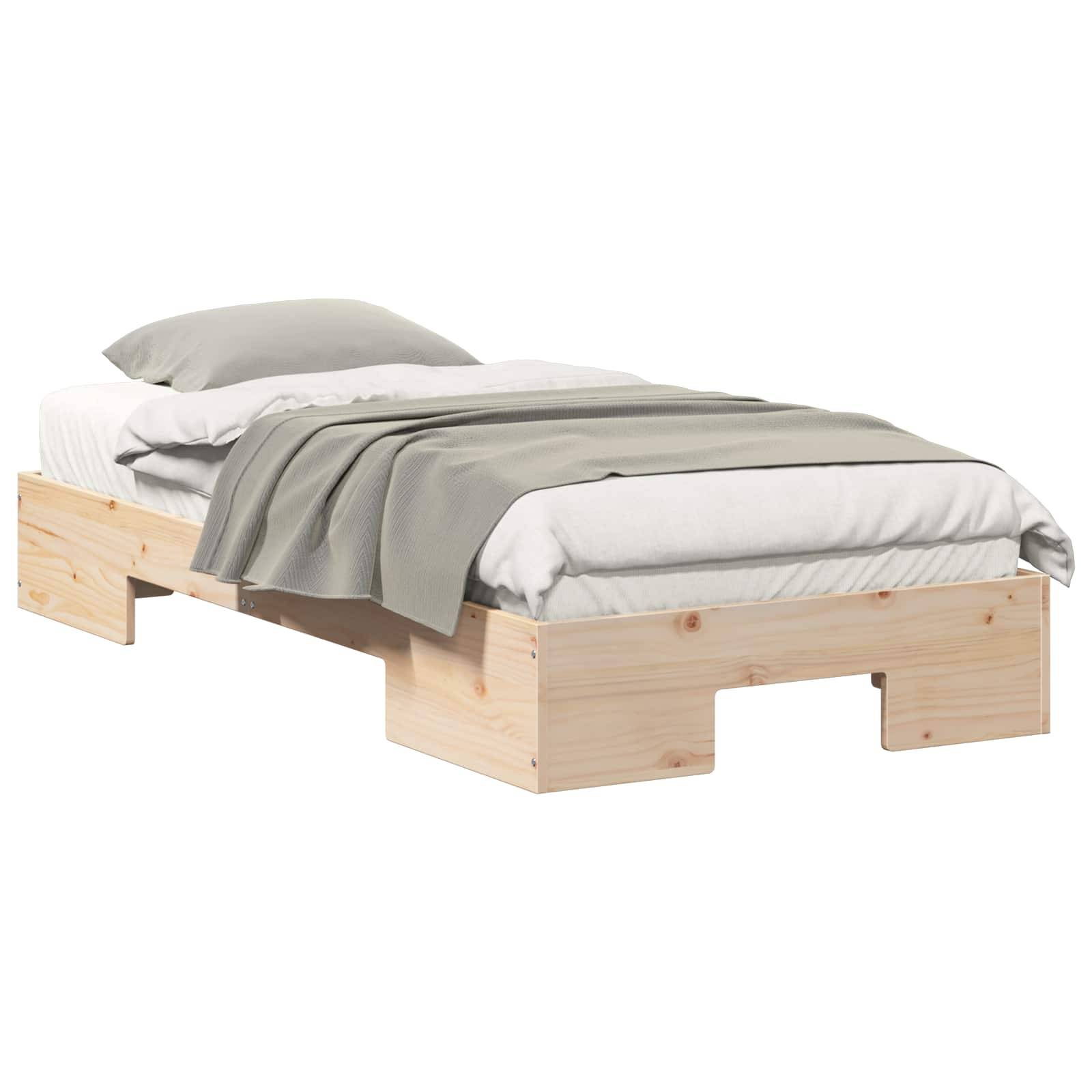 Einfaches Holzbettgestell mit weißer Matratze und Kissen, bedeckt von einer grauen Decke auf weißem Hintergrund.
