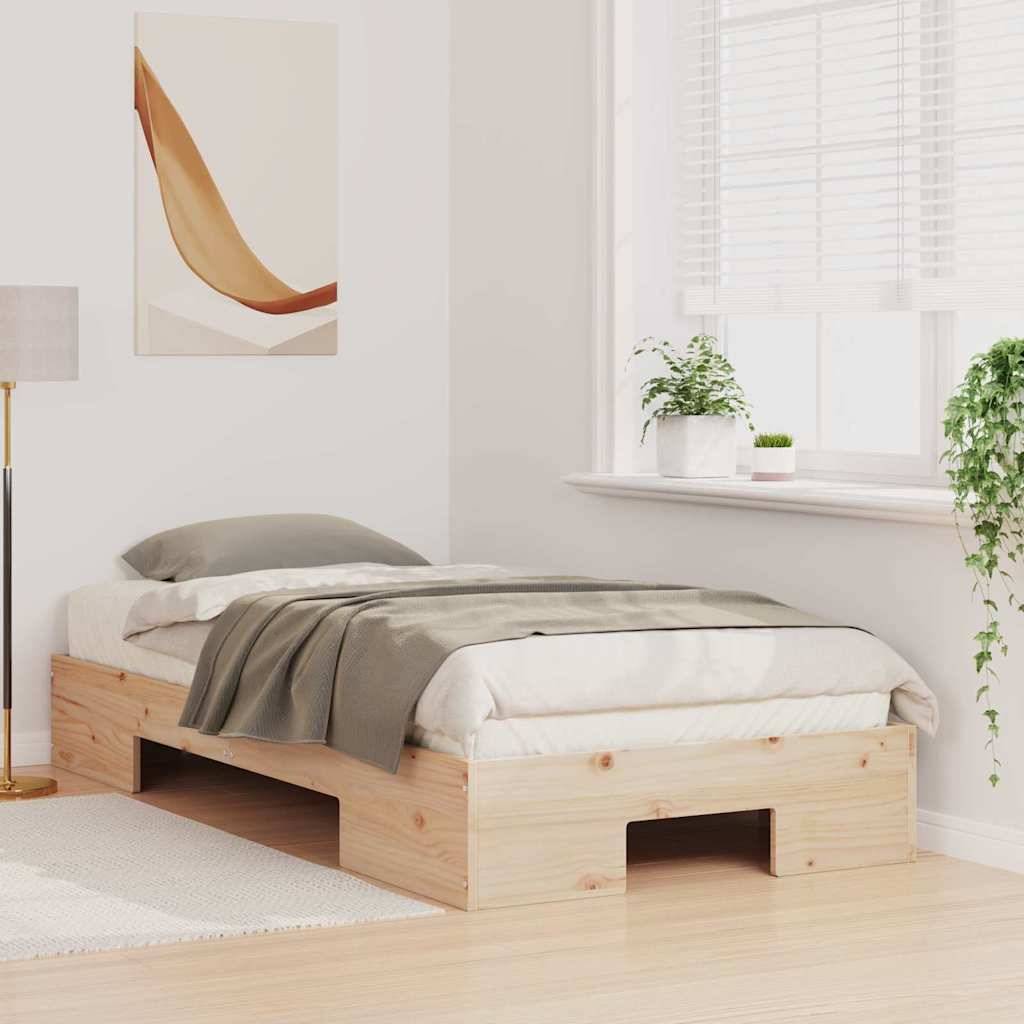 Minimalistisches Holzbettgestell mit grauer Bettwäsche in einem hellen Schlafzimmer, neben einem Fenster mit Pflanzen und einer Stehlampe.