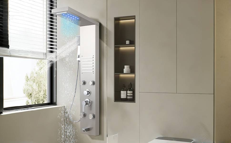 Modernes Badezimmer mit einem weißen wandmontierten Duschpaneel, das Wasser neben einem Fenster sprüht, neben einem eingelassenen Regal mit Toilettenartikeln.