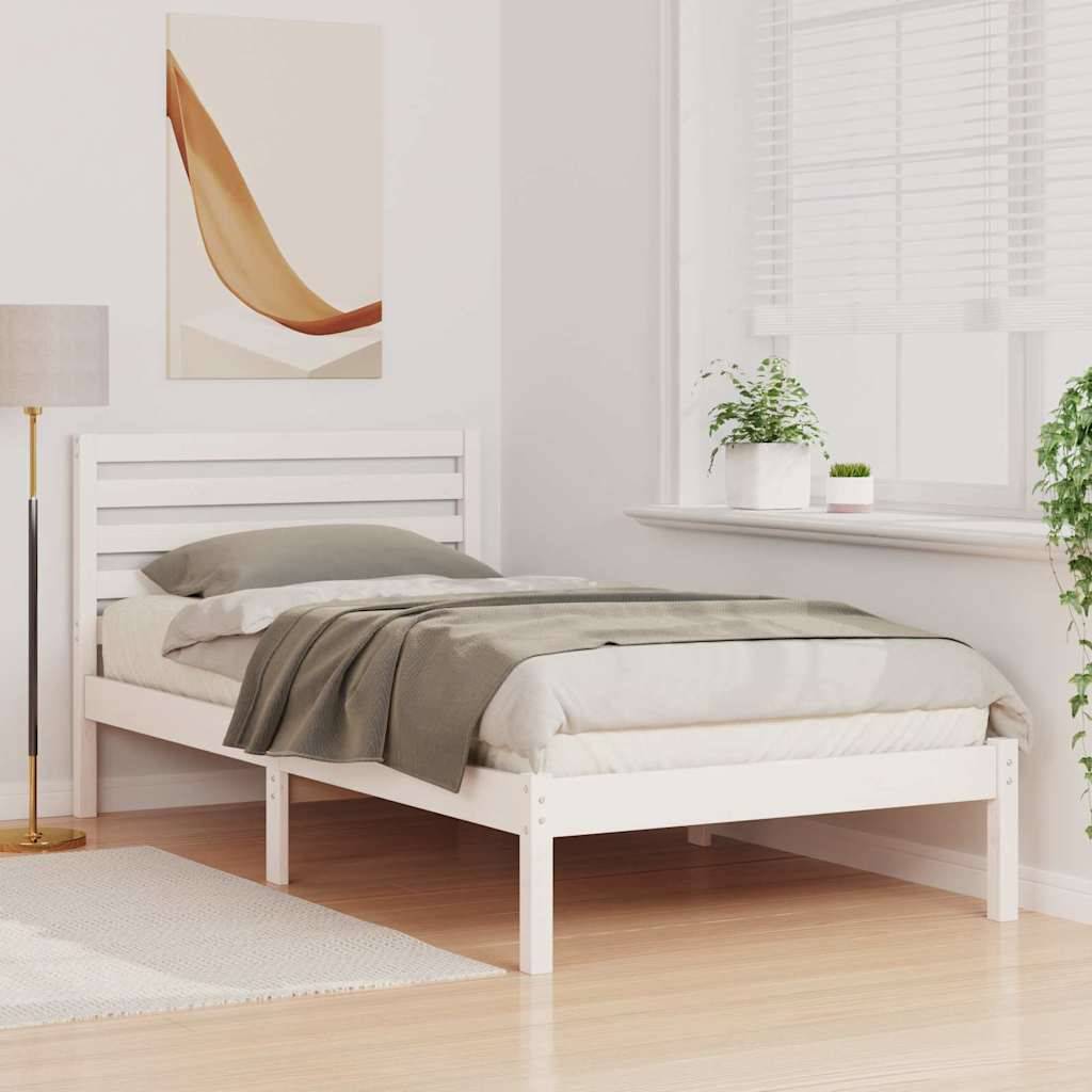 Ein gemütliches Schlafzimmer mit einem weißen Bett, grauen Bettwäsche, einem Nachttisch mit einer Lampe, einem großen Fenster mit Jalousien und einer Pflanze in der Ecke.