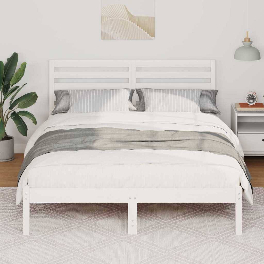 Ein ordentlich gemachtes Bett mit weißer und grauer Bettwäsche ist in einem hellen Schlafzimmer zentral platziert. Eine Pflanze und ein Nachttisch mit einer Lampe befinden sich auf jeder Seite.