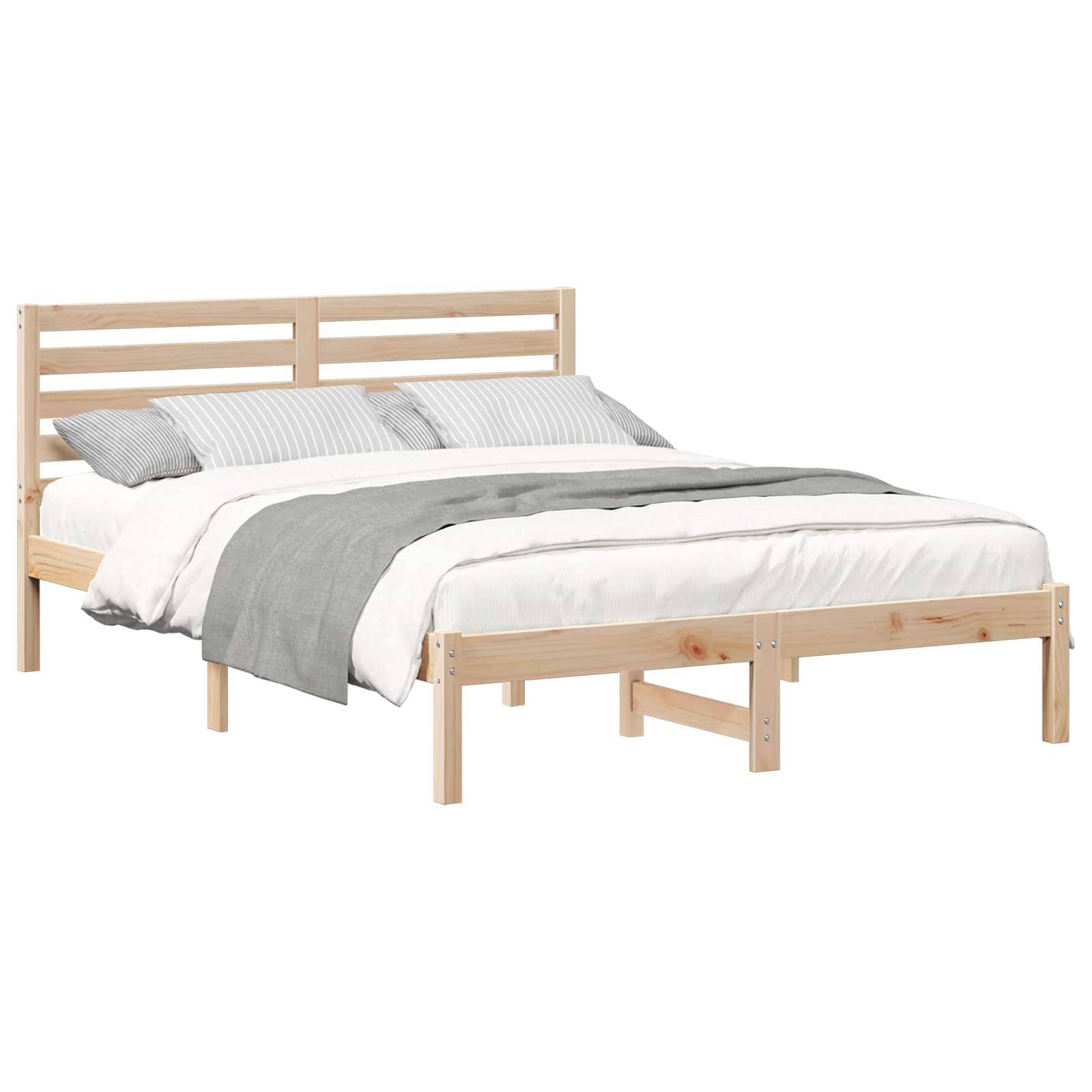 Ein Holzbettgestell mit einem Lattenrost als Kopfteil, bezogen mit weißer und grauer Bettwäsche.