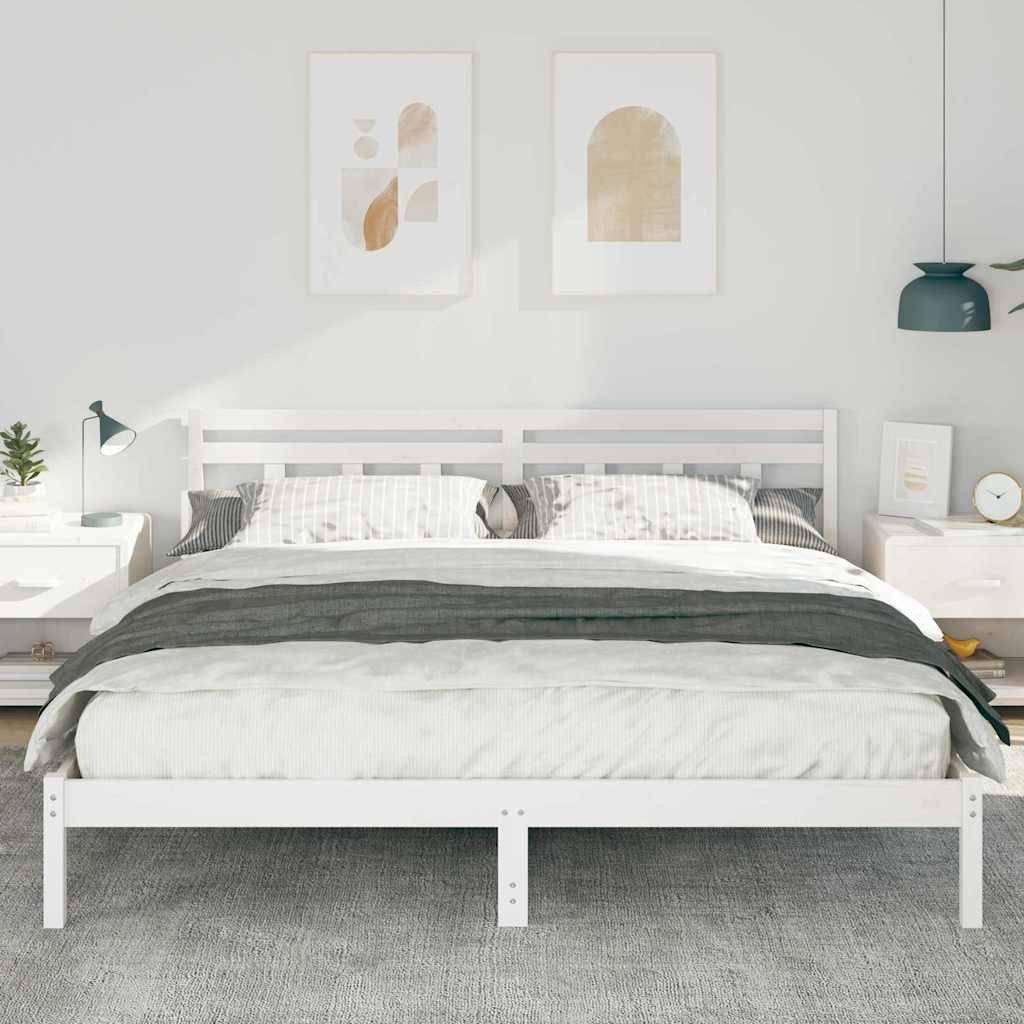 Minimales weißes Schlafzimmer mit einem ordentlich gemachtem Bett, das zwischen zwei Nachttischen zentriert ist, gerahmter Kunst darüber und einer hängenden Pendelleuchte.