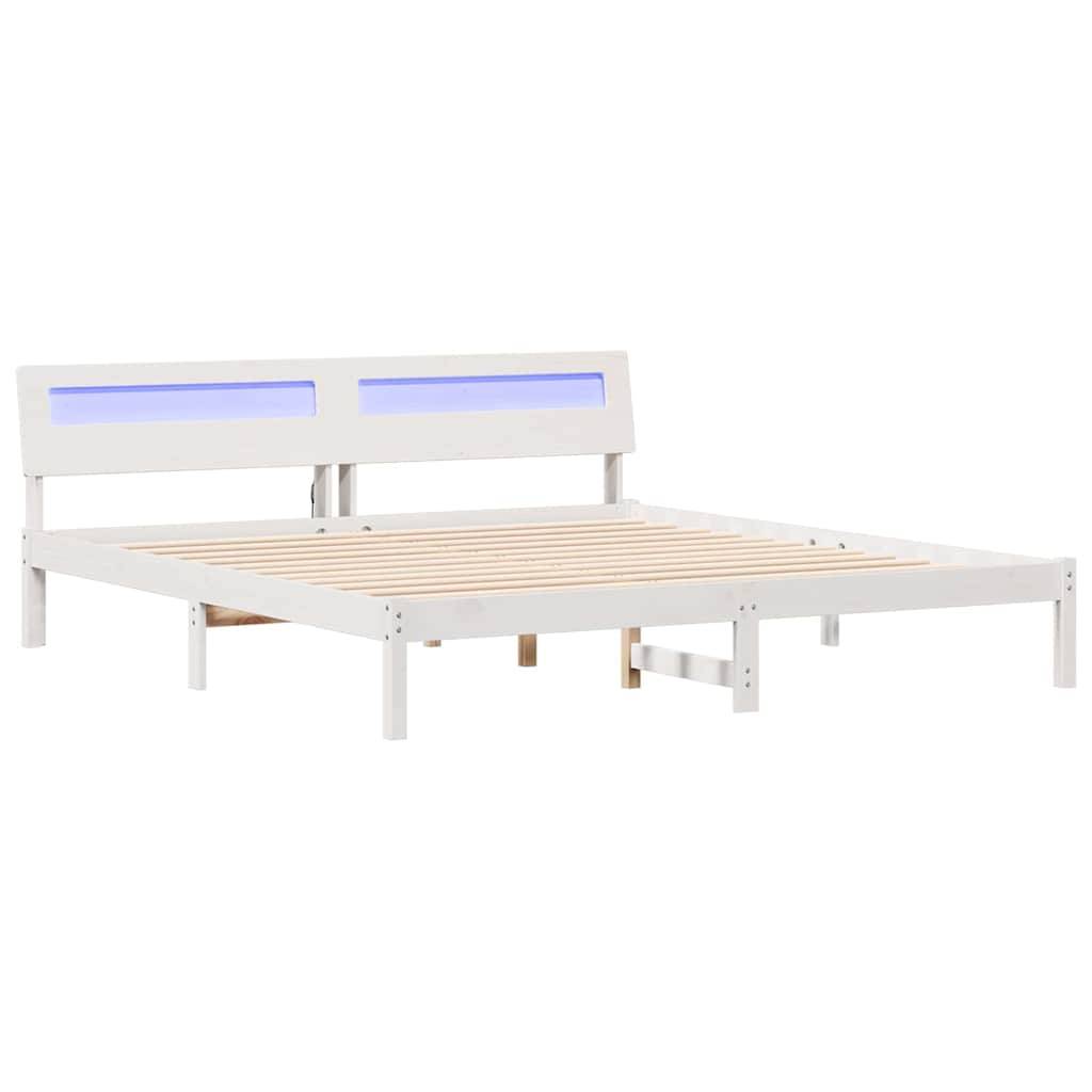 Ein weißer Holzbettrahmen mit Lattenrost und einem Kopfteil, das zwei horizontale, rechteckige Aussparungen mit blauer Hintergrundbeleuchtung aufweist.