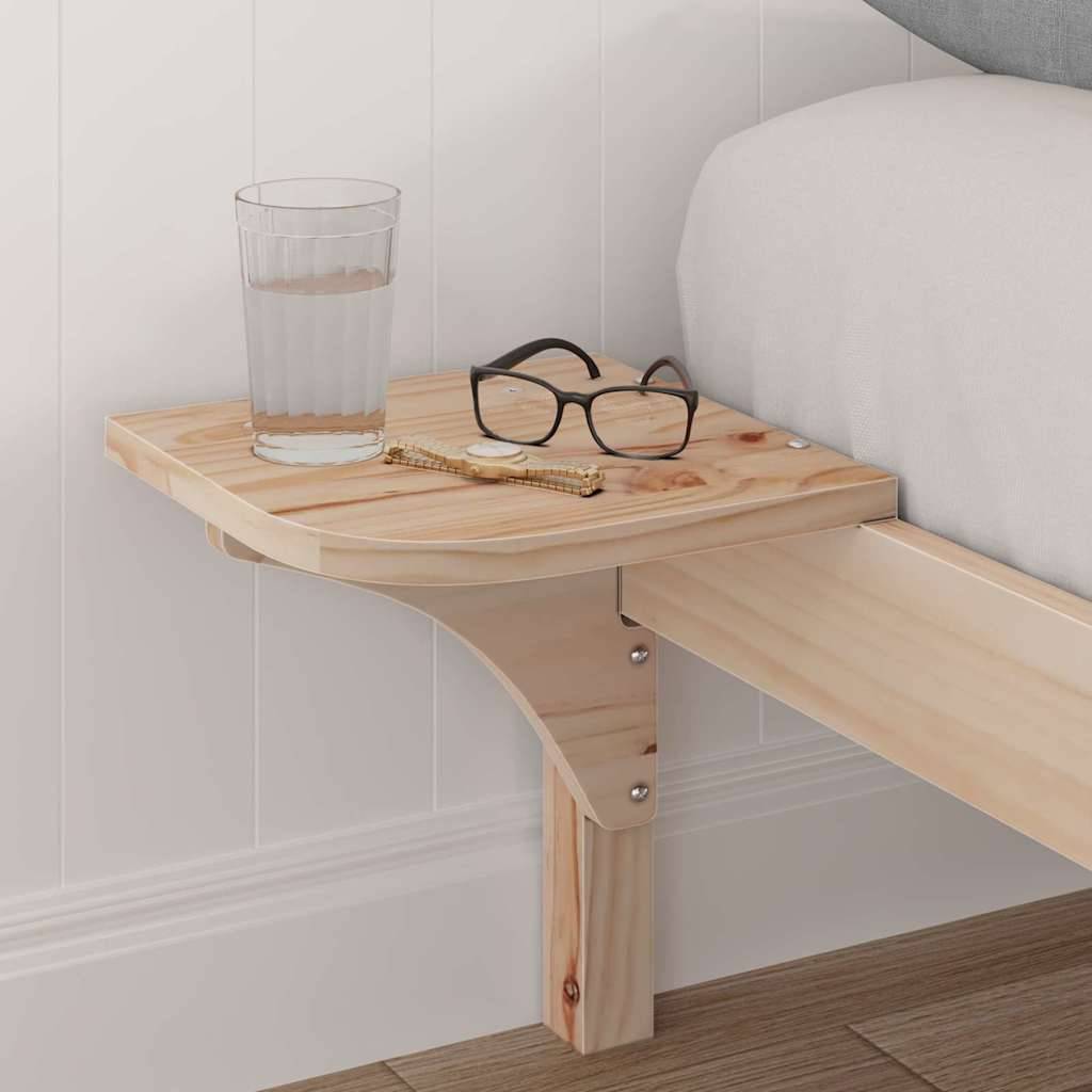 Ein kleines Holzregal am Bettrahmen, das an einem Nachttisch befestigt ist und ein Glas Wasser, eine Brille und einen Stift trägt, vor einer weißen Wand.