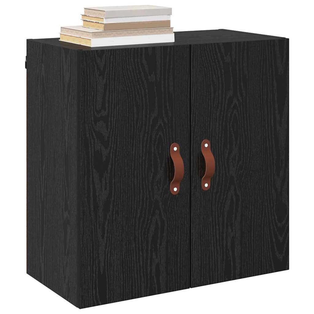Ein schwarzer Holzschrank mit zwei braunen Griffen und einem Stapel Bücher obenauf.