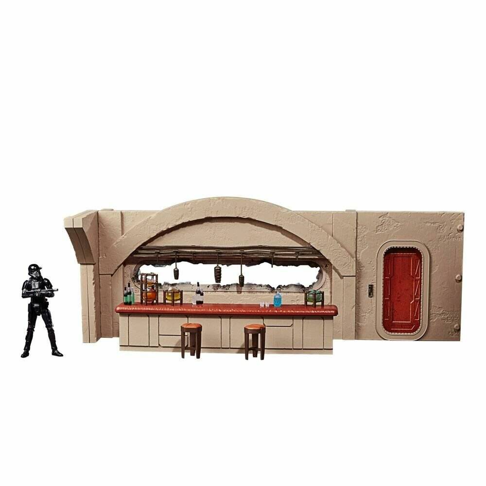 Spielzeug Sci-Fi Kantinen-Set mit Theke, Hockern, hängenden Leuchten, roter Tür und einer schwarzen bewaffneten Actionfigur, die daneben steht.
