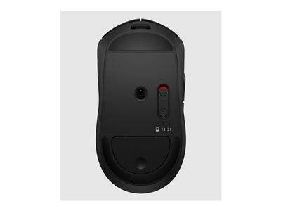 Eine schwarze Computermaus aus Untersicht mit Ein/Aus-Schalter, Sensor und Batteriefach auf einem hellgrauen Hintergrund.
