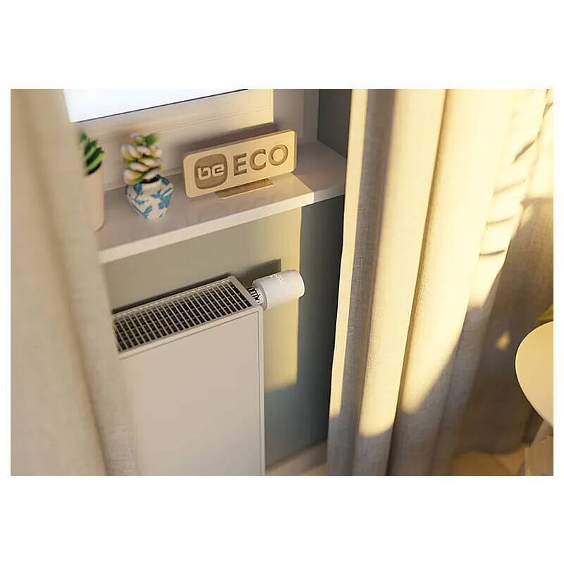 Ein Heizkörper unter einem Fenster mit einem Holzschild mit der Aufschrift „Be ECO