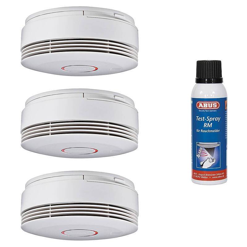 Drei kreisförmige Rauchmelder sind in einer vertikalen Reihe neben einer kleinen Flasche Rauchmelder-Prüfspray angeordnet.