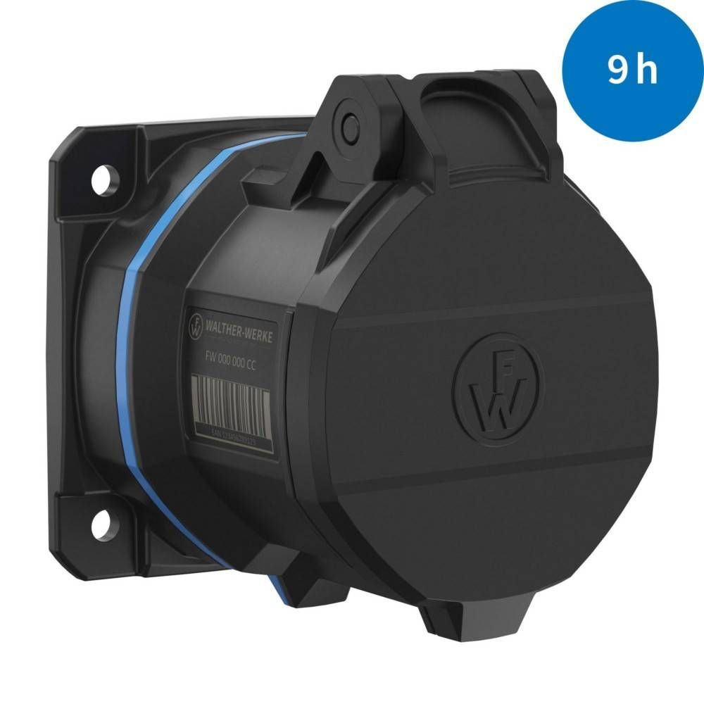 Eine schwarze elektrische Komponente, möglicherweise ein Anschluss oder eine Buchse, ist auf einer flachen Oberfläche montiert. Ein blauer Kreis in der Ecke zeigt '9h'.