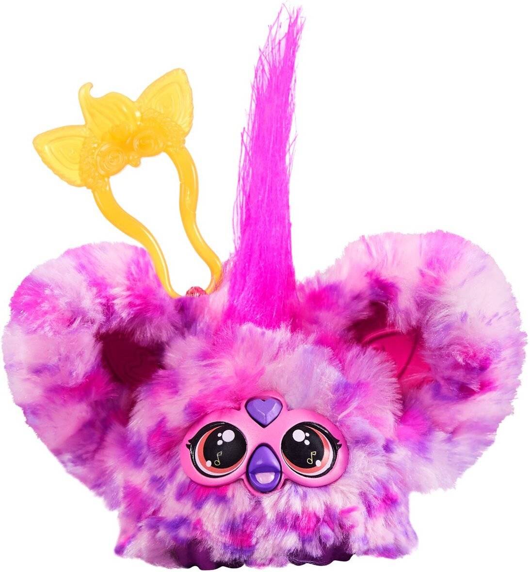 Ein rosa und lila Plüschtier mit großen Augen, herzförmigen Pupillen und einem langen Haarschopf. Das Spielzeug hat gelbe, antennenähnliche Ohren.