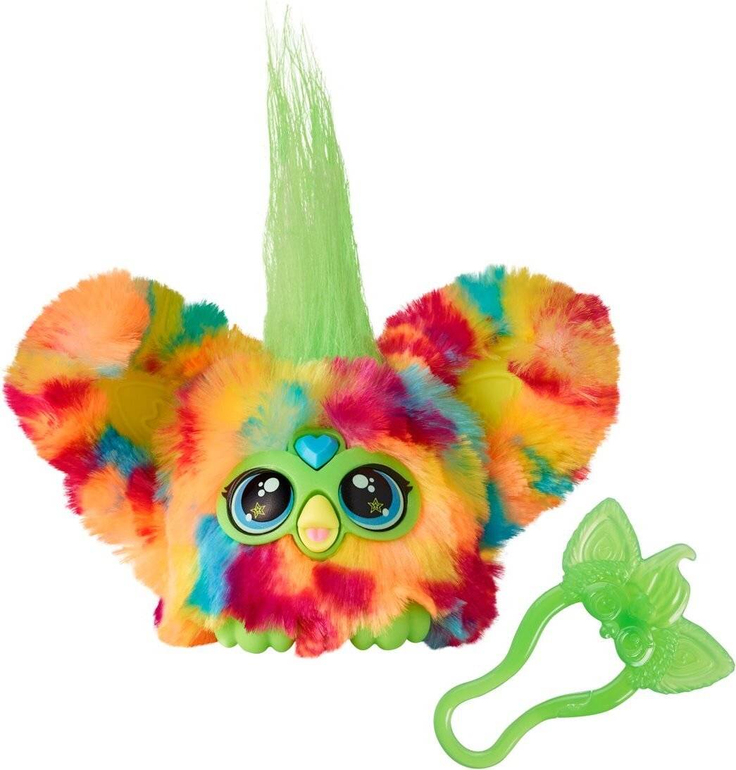 Ein buntes, flauschiges Spielzeug mit großen Augen und einem Büschel grüner Haare, begleitet von einem Paar grüner, schmetterlingsförmiger Accessoires.