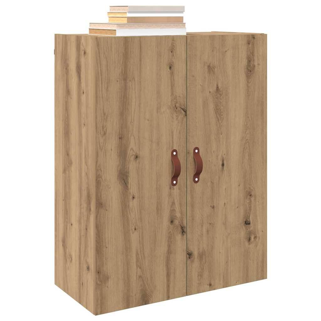 Ein Holzschrank mit zwei Türen, versehen mit dunklen Griffen. Mehrere Bücher sind darauf gestapelt.