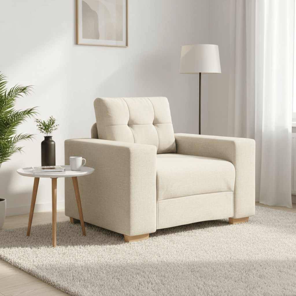 Ein gemütliches Wohnzimmer mit einem beigen Sessel und passendem Teppich, einem kleinen runden Tisch mit einer Kaffeetasse, einer Topfpflanze und einer Stehlampe.