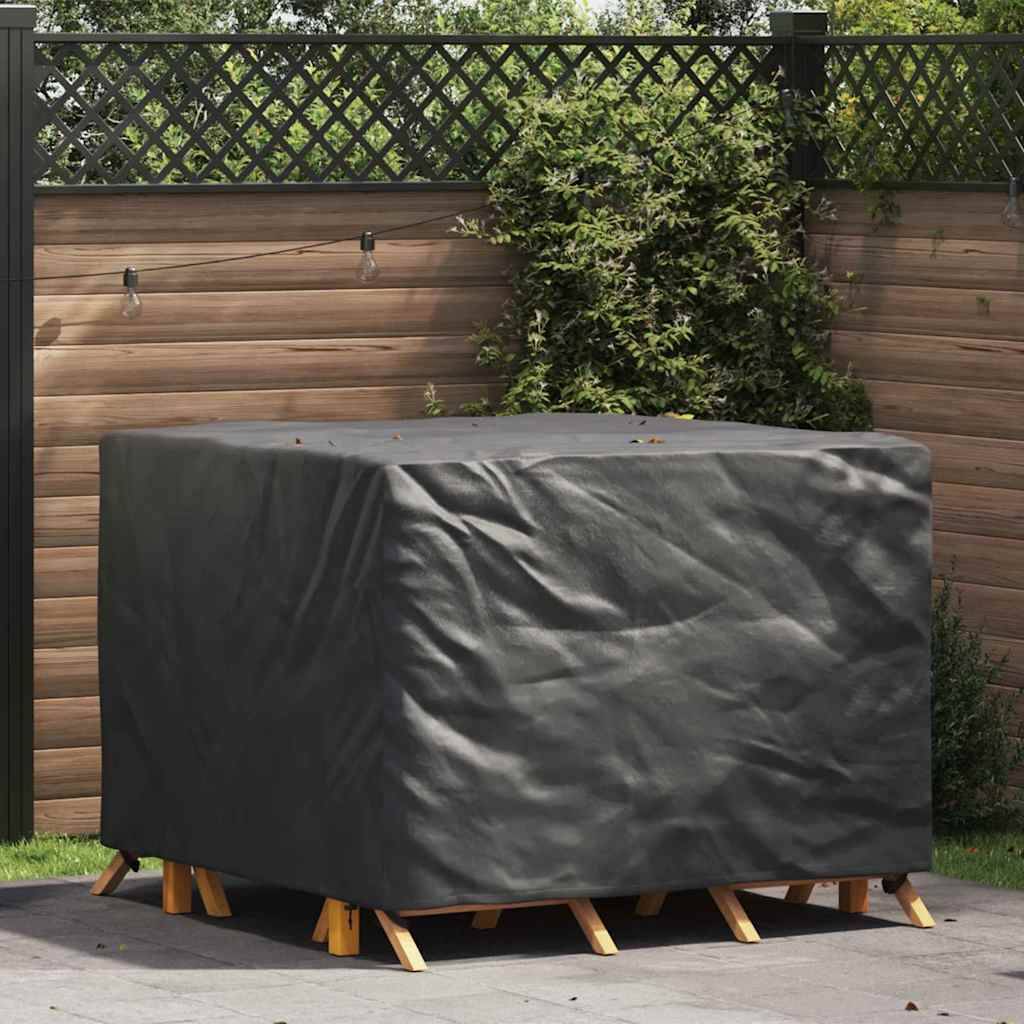 Ein überdachter Outdoor-Tisch auf einer Terrasse, umgeben von Blattwerk und einem Gitterzaun, was eine Gartenanlage zum Wetterschutz andeutet.