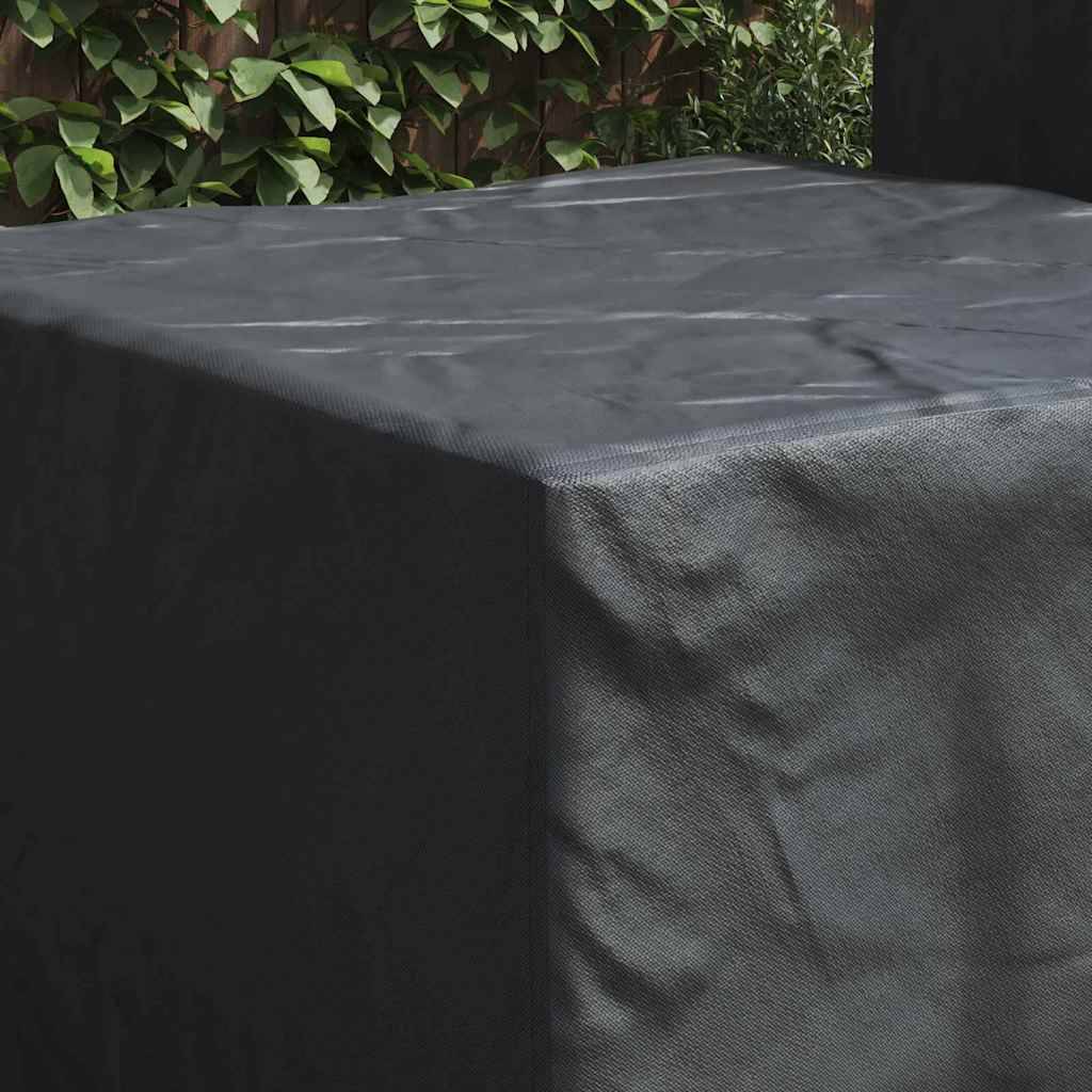 Eine große schwarze Schutzabdeckung, die über einen rechteckigen Tisch gehängt ist, mit einem Hintergrund von Grünpflanzen.