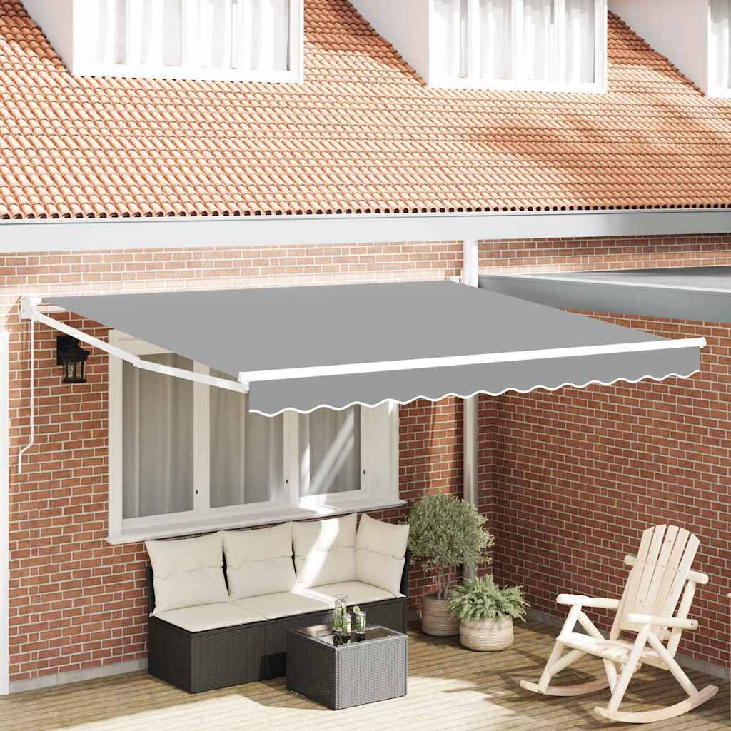 Eine Terrasse mit einer grauen ausfahrbaren Markise über einem Sitzbereich, der eine weiß gepolsterte Couch, einen Tisch und Pflanzen vor einer roten Ziegelwand umfasst.