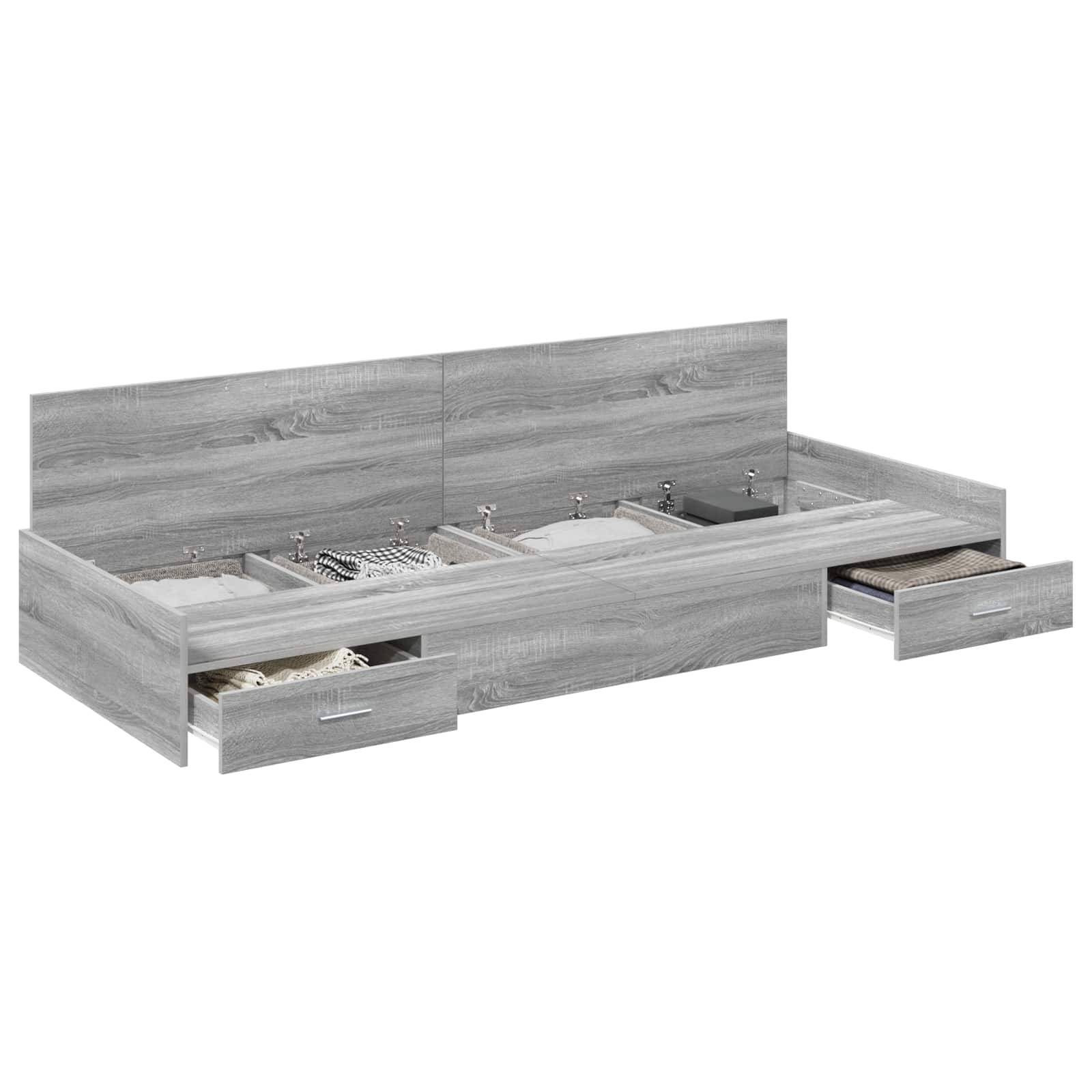Ein grauer Holzbettrahmen mit mehreren integrierten Aufbewahrungsschubladen, gefüllt mit gefalteter Kleidung und Accessoires, der organisierte Aufbewahrungslösungen präsentiert.