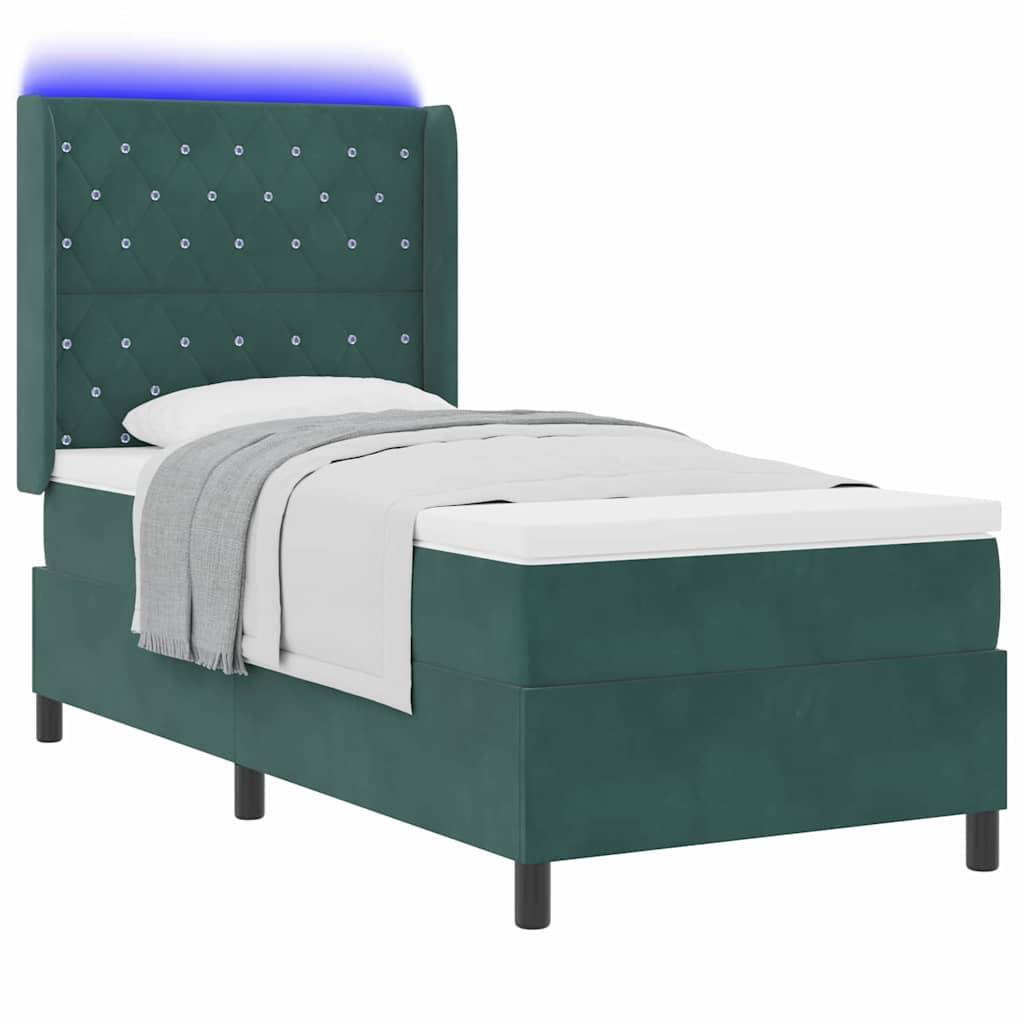 Ein türkisfarbenes Einzelbett mit einer gepolsterten, hohen Kopfseite, die durch Knopfdesigns akzentuiert wird. Die Bettwäsche umfasst eine weiße Matratze und Kissen, die mit einer grauen Kuscheldecke bedeckt sind.