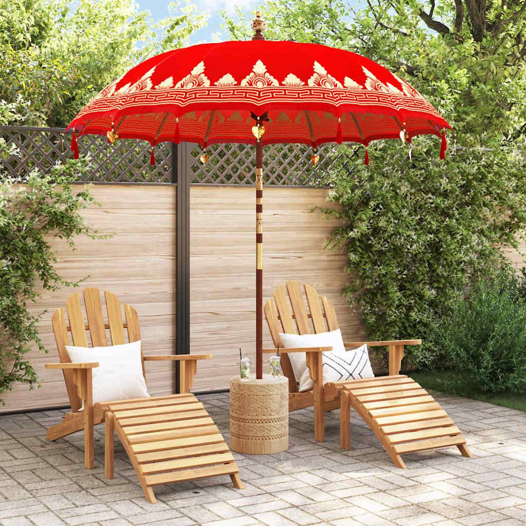 Eine ruhige Terrasse mit zwei Holzliegen und Stühlen unter einem lebhaft roten Sonnenschirm, vor einem Holzzaun mit grünem Blattwerk.