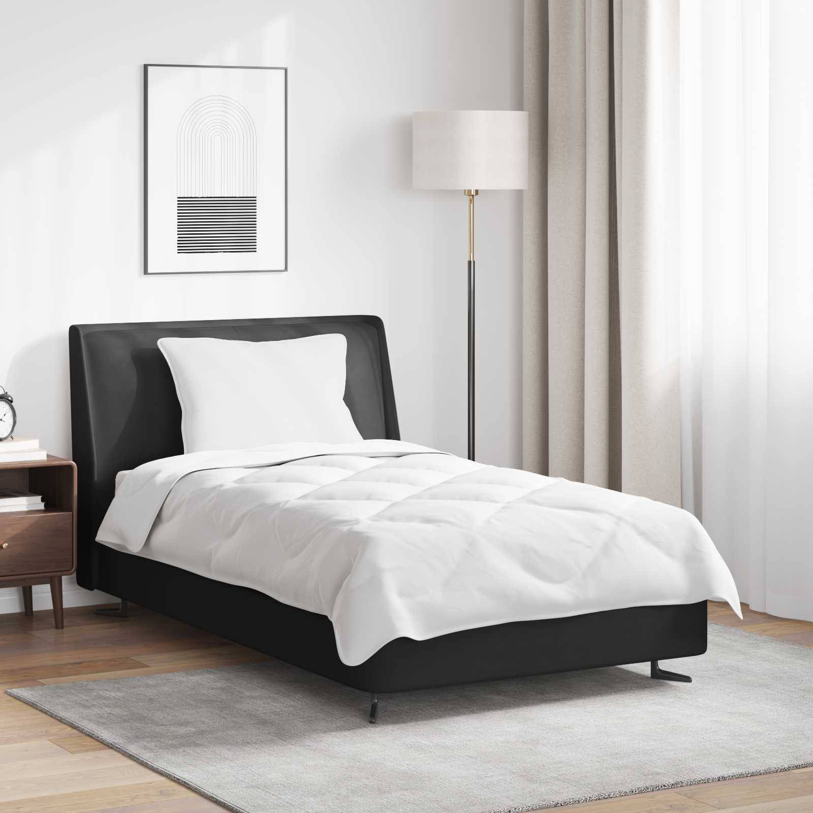 Ein modernes Schlafzimmer mit einem ordentlich gemachten Bett mit weißen Bettwäsche, einem Nachttisch, einer Lampe und einem gerahmten abstrakten Kunstwerk an der Wand.