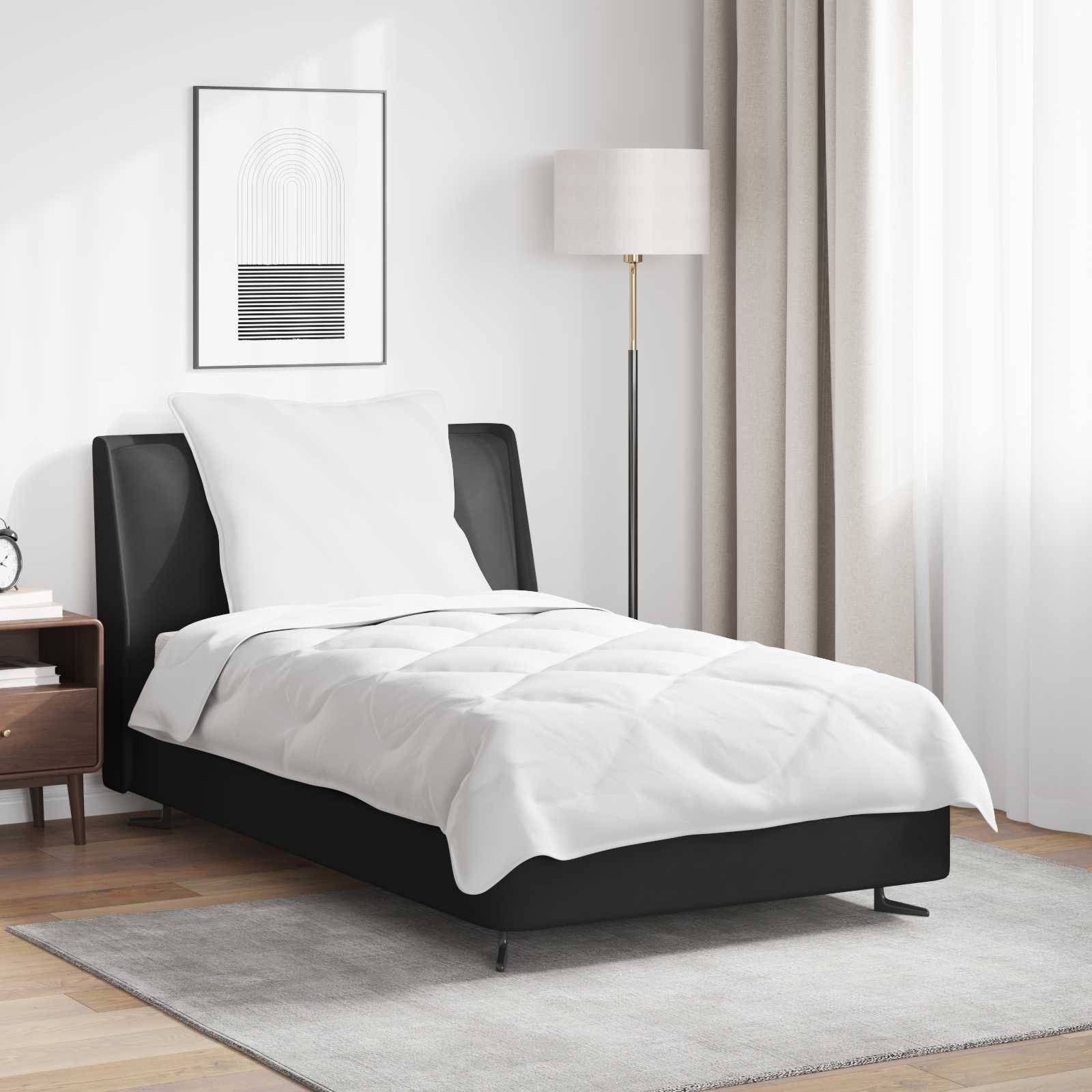 Ein modernes Schlafzimmer mit einem ordentlich gemachten Bett mit weißer Bettwäsche, einer hohen Stehlampe und einem gerahmten abstrakten Kunstwerk an der Wand.