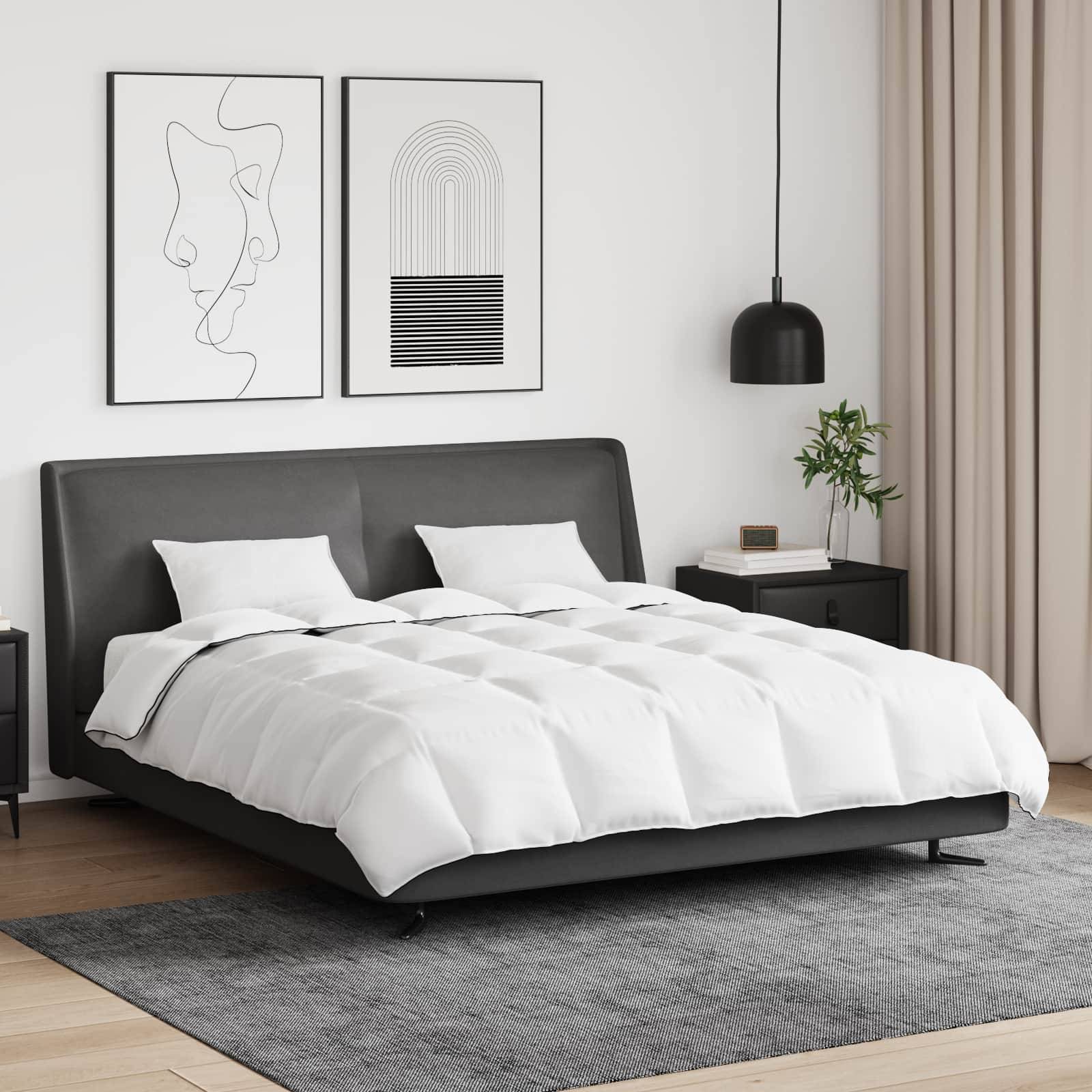 Ein modernes Schlafzimmer mit einem schlanken grauen Bett, weißer Bettwäsche und zwei abstrakten Kunstwerken an der Wand. Die Dekoration umfasst eine Pendelleuchte und eine Pflanze.