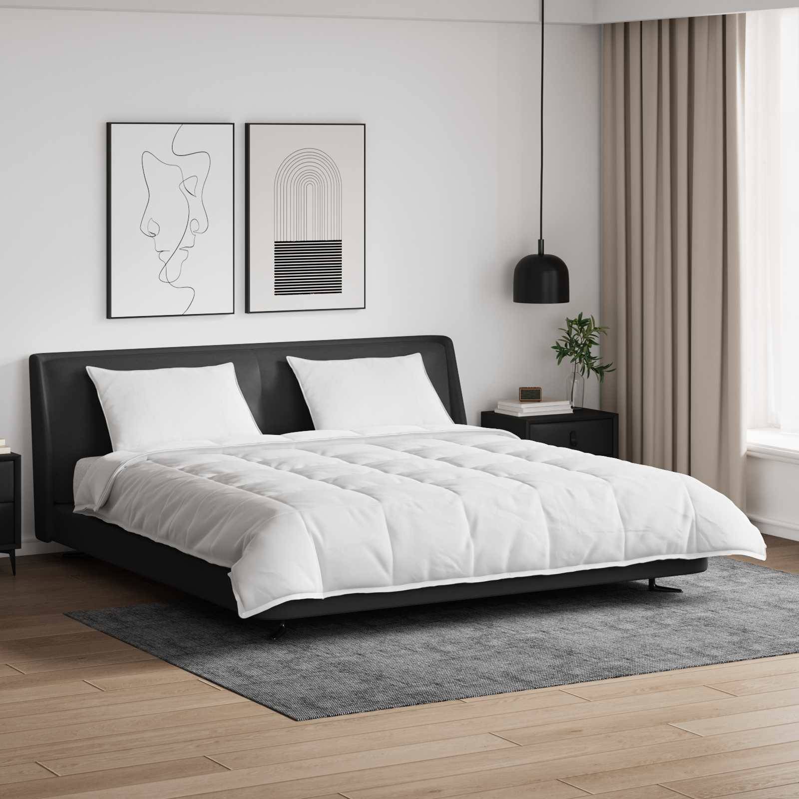 Ein modernes Schlafzimmer zeigt ein ordentlich gemachtes Doppelbett mit weißer Bettwäsche, schwarzem Kopfteil und zwei abstrakten Kunstwerken an der Wand darüber.
