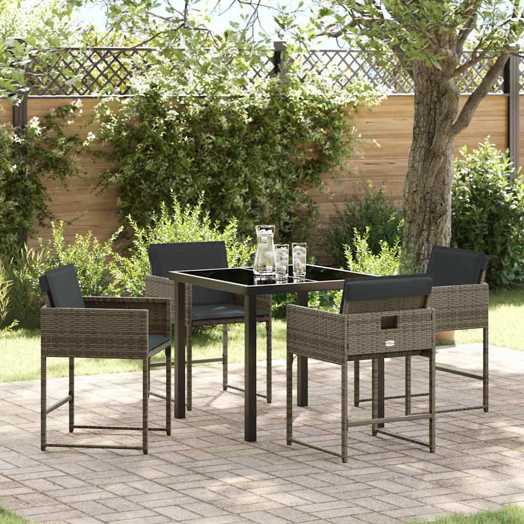 Überdachte Terrasse mit einem quadratischen Tisch, vier Stühlen und einem Glaskrug. Umgeben von Grünpflanzen und einem Holzzaun, der eine gemütliche Atmosphäre schafft.