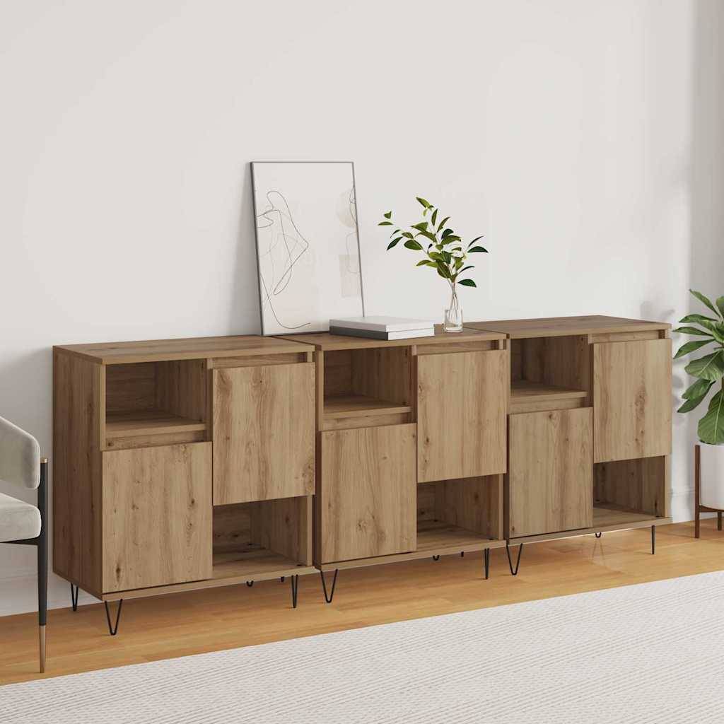 Ein Holzsideboard mit offenen Regalen und Schubladen steht an einer hellgefärbten Wand. Eine Topfpflanze und gerahmte Kunstwerke schmücken die Oberfläche.