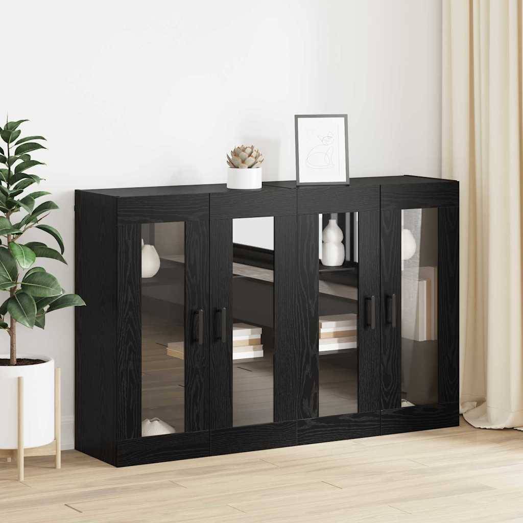 Ein moderner schwarzer Schrank mit Glastüren, in dem Bücher ausgestellt sind. Eine kleine Pflanze und ein gerahmtes Bild stehen darauf. Eine große Pflanze steht in der Nähe.