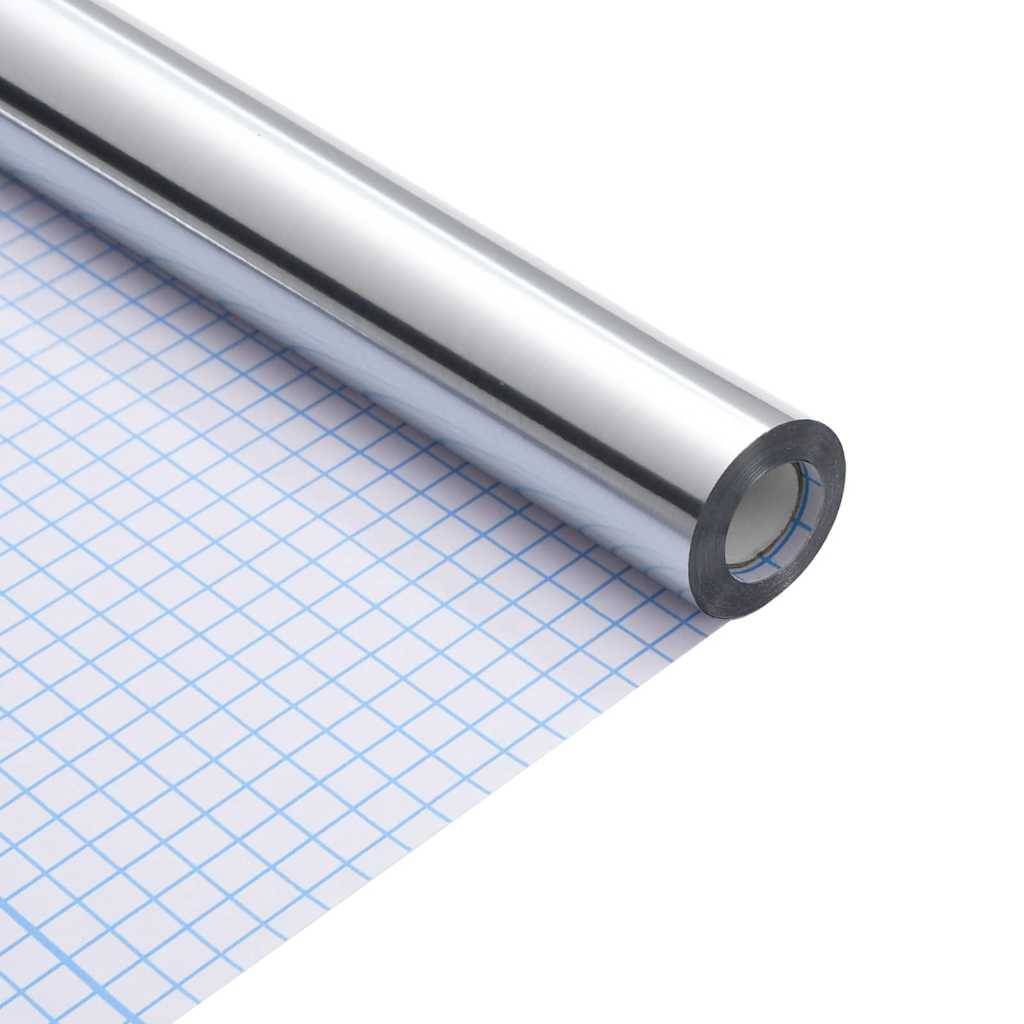 Eine Rolle Spiegelchrom-Klebevinyl liegt auf einem Blatt blauem Rasterzeichenpapier und zeigt ihre reflektierende und glatte Oberfläche.