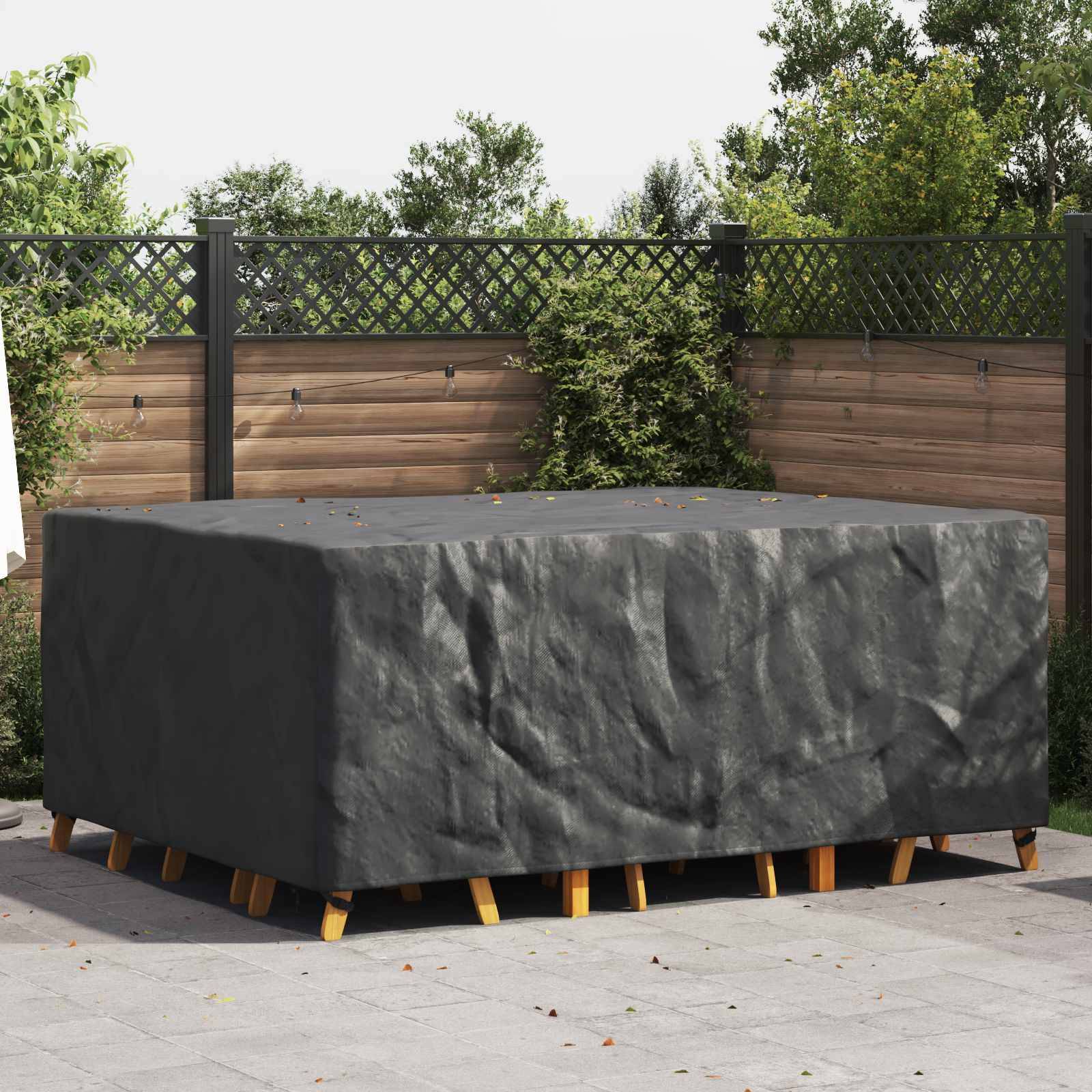 Ein überdachter Terrassentisch-Set in einem Hinterhof mit einem Holzzaun und Grünflächen im Hintergrund, was auf den Schutz von Gartenmöbeln hindeutet.