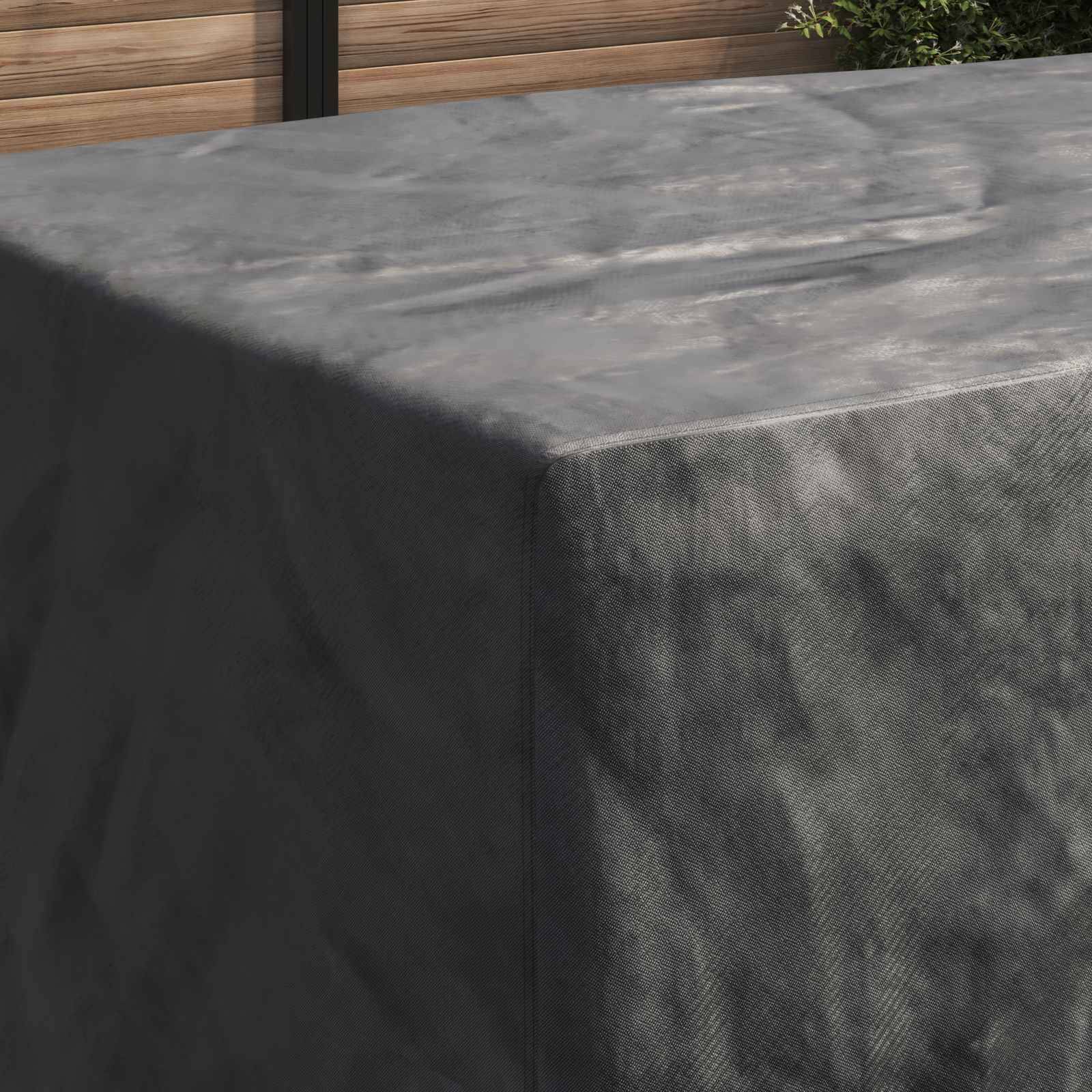 Ein grauer, mit Stoff bezogener Outdoor-Tisch vor einer Holzwand im Hintergrund, teilweise von Sonnenlicht beschattet.