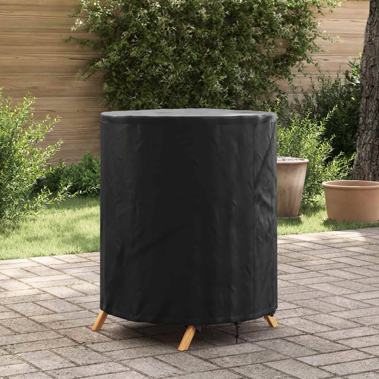 Ein rundes, überdachtes Gartenmöbelstück auf einer Steinterrasse, umgeben von Grünpflanzen und einem Holzzaun im Hintergrund.