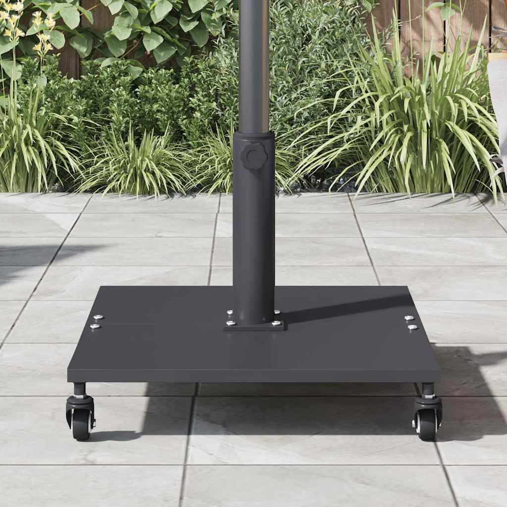 Das Bild zeigt eine schwarze Schirmständerhalterung mit Rädern auf einer gefliesten Terrasse. Grüne Pflanzen und ein Holzzaun befinden sich im Hintergrund.