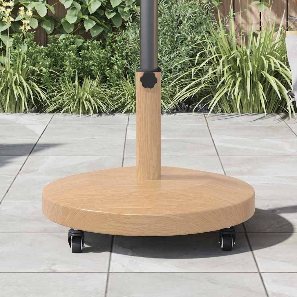 Ein hölzerner Schirmständer auf einer Terrasse mit Grünpflanzen im Hintergrund, versehen mit einer zylindrischen Basis und Rollen für mobile Beweglichkeit.