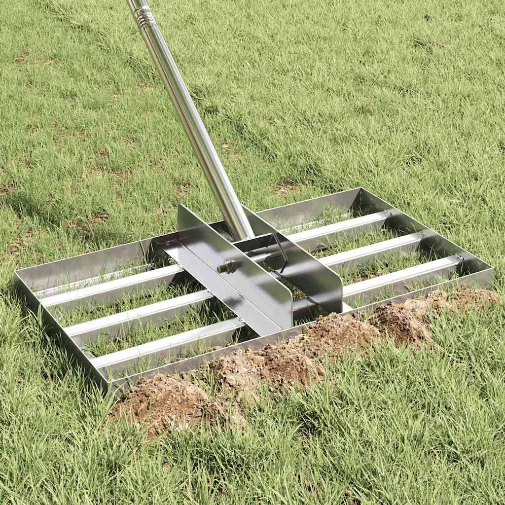 Ein Metall-Rasenausgleichsrechen mit Gitterdesign wird auf einem grasbedeckten Rasen platziert und ebnet den Boden darunter im Rahmen der Gartenlandschaftspflege.