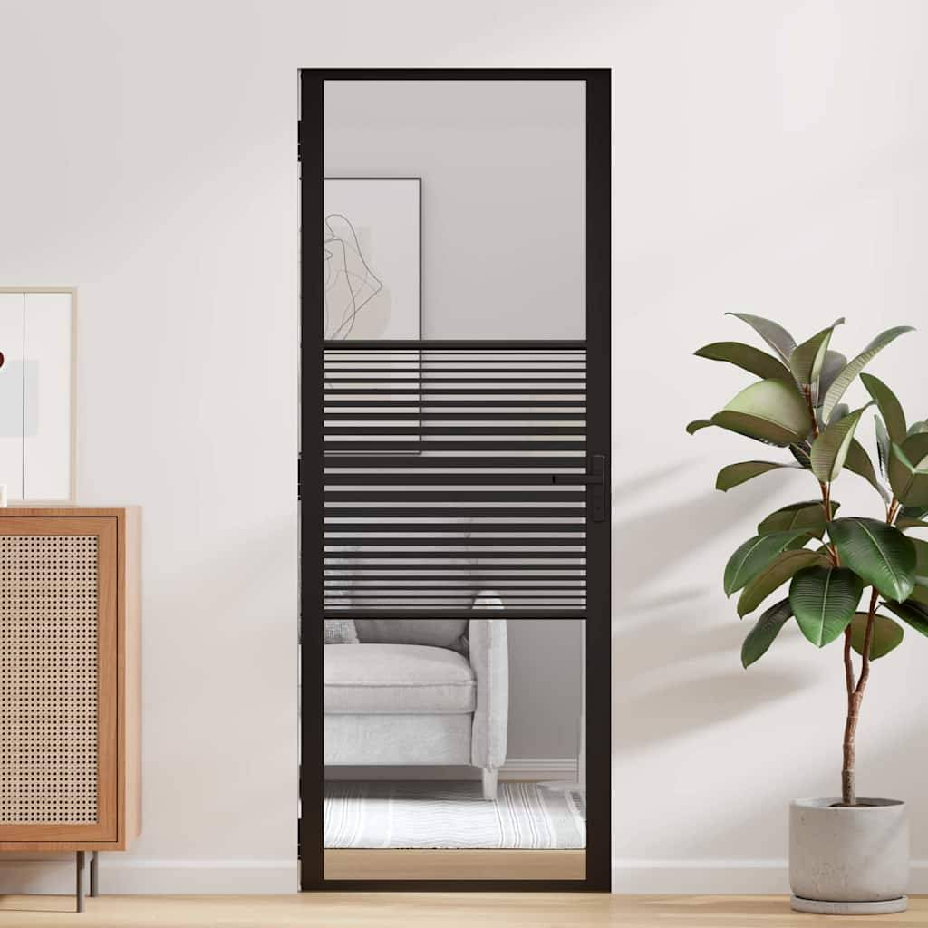 Ein moderner Wohnraum zeigt eine Glastür mit horizontalen schwarzen Linien, neben einer grünen Pflanze und einem teilweise sichtbaren weißen Sofa im Innenraum.