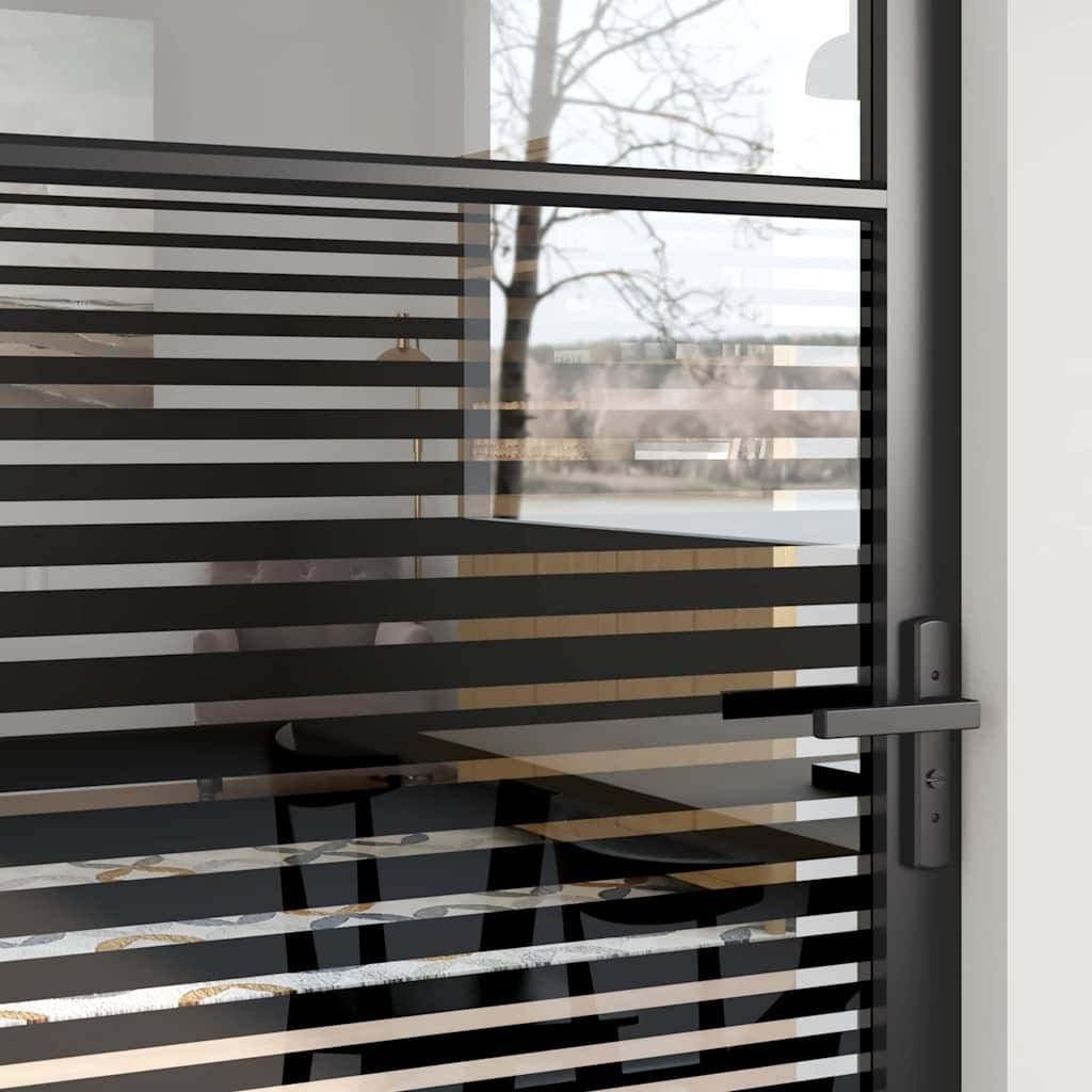 Moderne Glastür mit horizontalen schwarzen Streifen, die einen verschwommenen Blick auf eine Außenszene mit kahlen Bäumen rahmt. Ein Spiegelbild zeigt einen Tisch und einen Stuhl im Inneren.