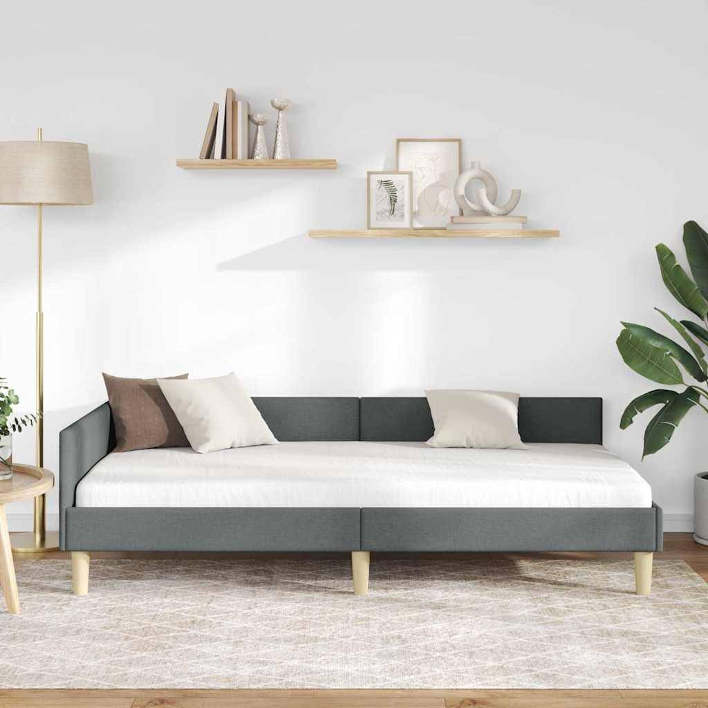 Ein modernes Wohnzimmer mit einem grauen Tagesbett und weißen Kissen, flankiert von einer hohen Stehleuchte und einer Pflanze. Minimalistische Regale halten Dekorationsgegenstände.