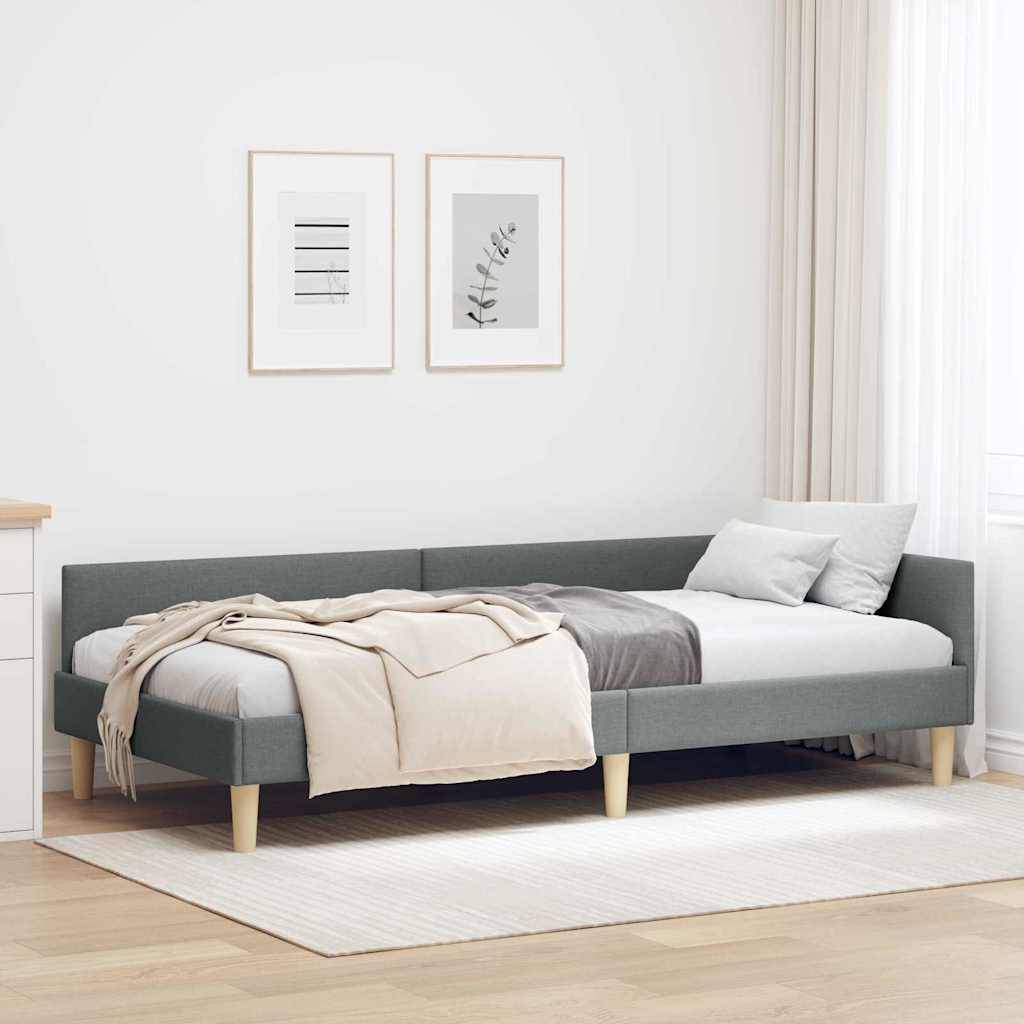 Ein modernes Schlafzimmer mit einem grauen Podestbett, weißer Bettwäsche, zwei dekorativen Rahmen an der Wand darüber und hellem Holzmöbeln und Holzfußboden.