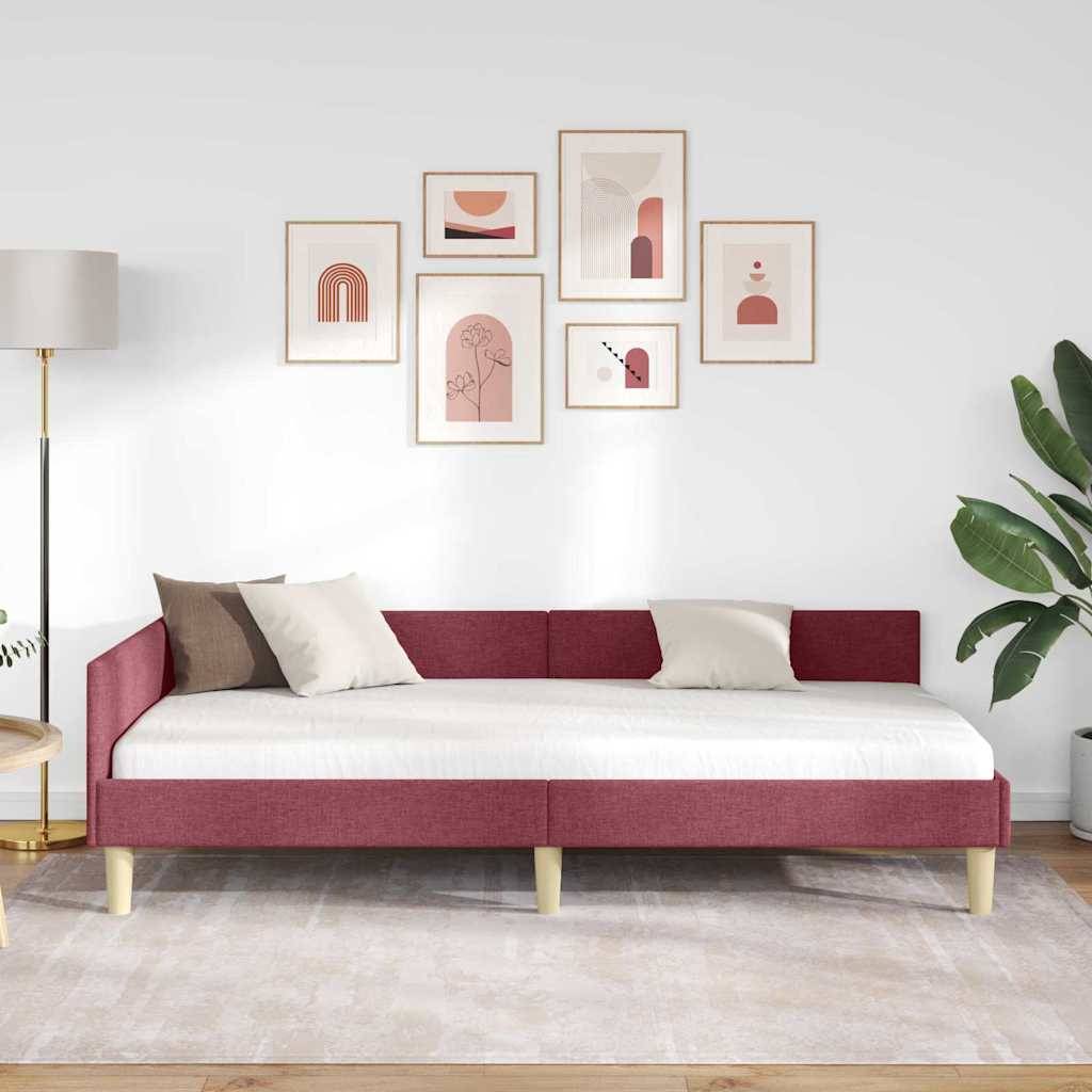Ein modernes Wohnzimmer mit einem rosa Sofa, einer goldenen Stehlampe, sechs abstrakten Kunstwerken an der Wand, einer großen grünen Pflanze und einem beigen Teppich.