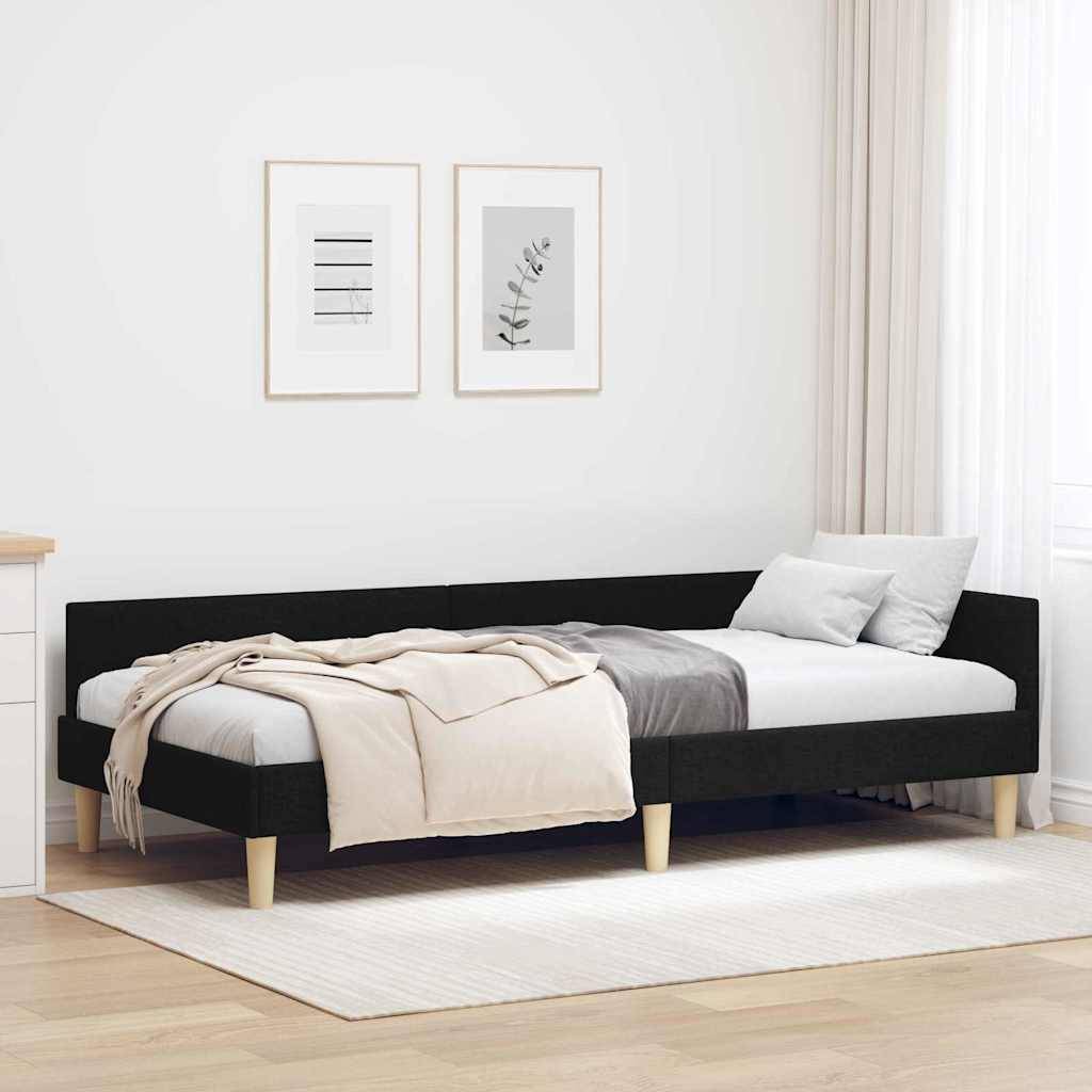 Ein modernes Schlafzimmer mit schwarzem Bettrahmen, beige und weißer Bettwäsche, hellen Holzbeinen und zwei gerahmten botanischen Drucken an der Wand.