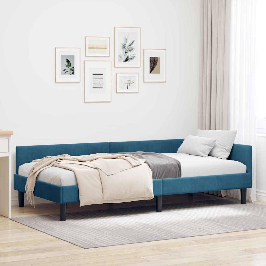 Ein modernes Schlafzimmer mit einem blauen Polster-Plattformbett, beigen Decken und dekorativen Bildern in Rahmen an einer weißen Wand. Minimalistische Einrichtung.