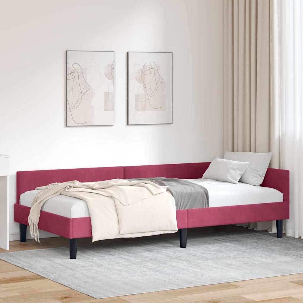 Ein modernes Schlafzimmer mit einem roten, flachen Bett, weißer Bettwäsche und abstrakter Kunst an der Wand. Beige Vorhänge und ein hellgrauer Teppich runden die Einrichtung ab.